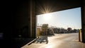 Sunlight streams into a warehouse loading dock with pallets and shelving visible inside Royalty Free Stock Photo