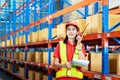 Warehouse logistic management business. young Asian woman wearing reflective safty vest and white helmet, Communicating via walky-