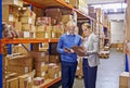 Warehouse, man and woman with tablet, supply chain and inventory with cooperation and industrial. Clipboard, supervisor