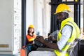 Warehouse man worker driver forklift. warehouse worker driver stacking card boxes by forklift in warehouse store. African American Royalty Free Stock Photo