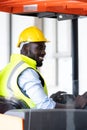 Warehouse man worker driver forklift. warehouse worker driver stacking card boxes by forklift in warehouse store. African American Royalty Free Stock Photo