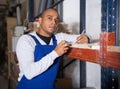 Warehouse manager calculates the quantity of goods and writes it down in notebook