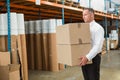 Warehouse manager carrying cardboard boxes