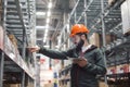 Warehouse manager checking his inventory in a large warehouse Royalty Free Stock Photo