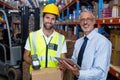 Warehouse manager holding digital tablet while male worker scanning barcode Royalty Free Stock Photo