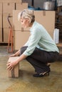 Warehouse manager picking up cardboard box