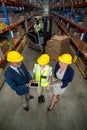 Warehouse manager using digital tablet with client and female worker Royalty Free Stock Photo