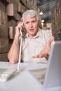 Warehouse manager using telephone and laptop Royalty Free Stock Photo