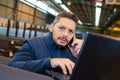 warehouse manager using telephone and laptop in large warehouse Royalty Free Stock Photo