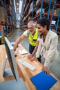 Warehouse manager and worker discussing with computer Royalty Free Stock Photo