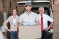 Warehouse managers and delivery driver smiling at camera Royalty Free Stock Photo