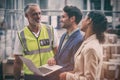 Warehouse managers and worker discussing with laptop Royalty Free Stock Photo