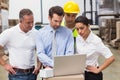 Warehouse managers and worker looking at laptop Royalty Free Stock Photo