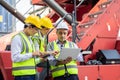 Warehouse managers and worker working on laptop in a large warehouse. They Work at the Heavy Industry Manufacturing Facility Royalty Free Stock Photo