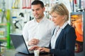 warehouse managers working together on laptop in large warehouse Royalty Free Stock Photo