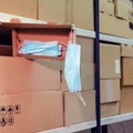 Warehouse with opened boxes of medical masks. Theft of face masks at a postal warehouse during quarantine due to coronavirus