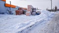Warehouse store in the open air in winter in the city. Sacks with cement and putty on a wooden pallet, for opening on