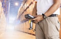 Warehouse supervisor holding barcode scanner. Inventory management cargo on tall shelves. Warehousing and Logistics.
