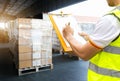 Warehouse worker courier hand holding clipboard inspecting load shipment goods Royalty Free Stock Photo