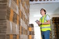 Warehouse worker courier inspecting checklist stock cardboard boxes for sale