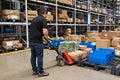 Warehouse worker dragging hand pallet truck or manual forklift with the shipment pallet unloading into a truck. Distribution,