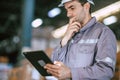 Warehouse worker, Engineer manager looking at tablet screen with thinking have a problem expression Royalty Free Stock Photo