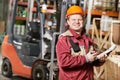 Warehouse worker in front of forklift Royalty Free Stock Photo