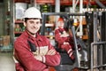 Warehouse worker in front of forklift Royalty Free Stock Photo