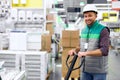 Warehouse worker with hand pallet truck or pallet jack and the shipment in store Royalty Free Stock Photo