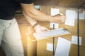 Warehouse worker holding clipboard his doing inventory management cargo boxes. Checking stock, Cargo shipment, Warehousing storage Royalty Free Stock Photo