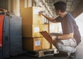 Warehouse worker holding clipboard his doing inventory management package boxes. Checking stock, Warehousing. Cargo shipment boxes Royalty Free Stock Photo