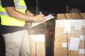 Warehouse worker holding clipboard his doing inventory management the product. Checking stock, Warehousing. Cargo shipment boxes. Royalty Free Stock Photo