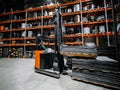 Warehouse worker lifts a load on a forklift