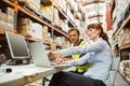 Warehouse worker and manager looking at laptop