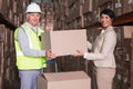 Warehouse worker and manager passing a box Royalty Free Stock Photo