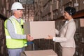 Warehouse worker and manager passing a box Royalty Free Stock Photo