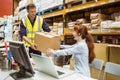 Warehouse worker and manager passing a box Royalty Free Stock Photo