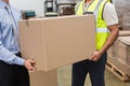 Warehouse worker and manager passing a box Royalty Free Stock Photo