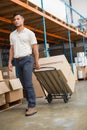 Warehouse worker moving boxes on trolley Royalty Free Stock Photo