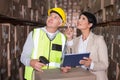 Warehouse worker scanning box with manager