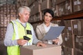 Warehouse worker scanning box with manager