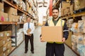 Warehouse worker smiling at camera carrying a box Royalty Free Stock Photo