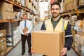 Warehouse worker smiling at camera carrying a box Royalty Free Stock Photo