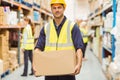 Warehouse worker smiling at camera carrying a box Royalty Free Stock Photo