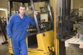 Warehouse worker standing by forklift Royalty Free Stock Photo