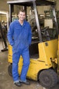 Warehouse worker standing by forklift Royalty Free Stock Photo