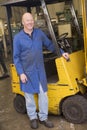 Warehouse worker standing by forklift Royalty Free Stock Photo