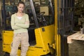 Warehouse worker standing by forklift Royalty Free Stock Photo