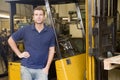 Warehouse worker standing by forklift Royalty Free Stock Photo