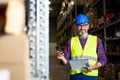 Warehouse worker talking on the phone holding clipboard in a warehouse Royalty Free Stock Photo